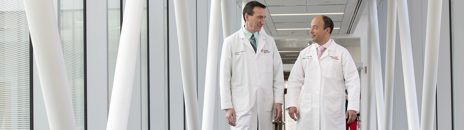 Dr. Espay with doctor walking through hallway of UC Gardner Neuroscience Institute building