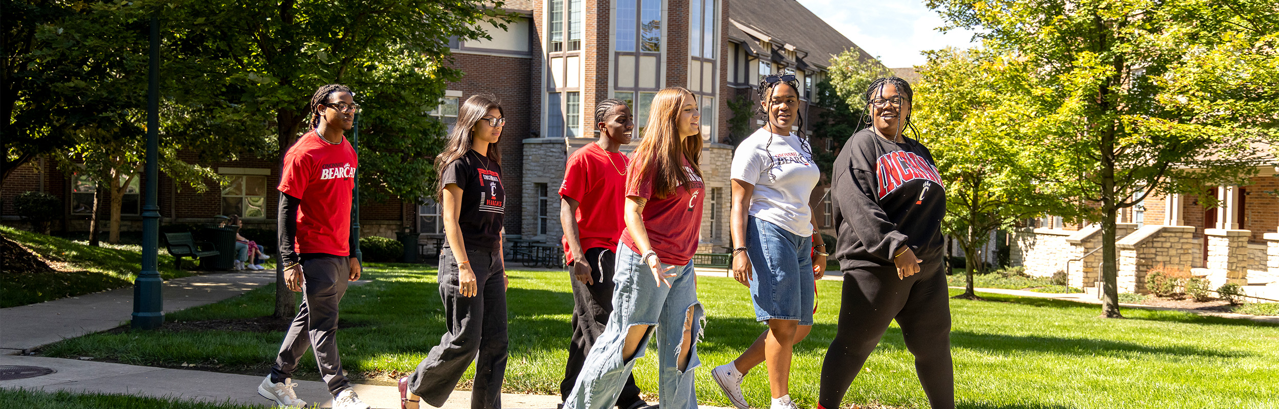 Six students walking in front of UC's 1MPACT House.